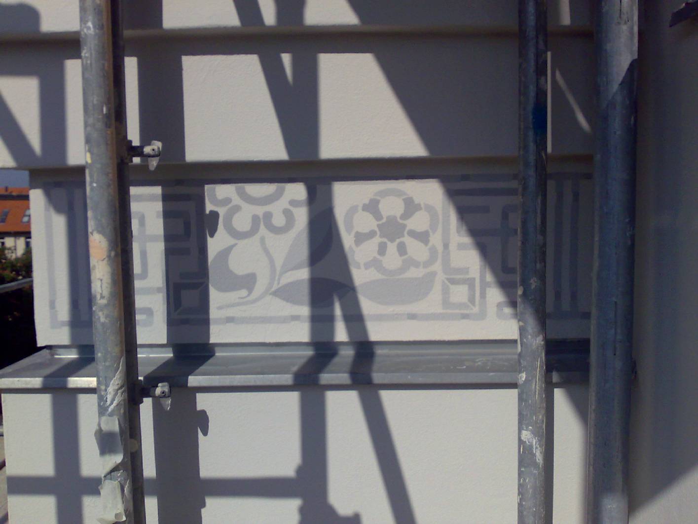 Schablone / Schablonierung und Begleitstriche an einer Fassade aus Berlin im Jugendstil als Graumalerei. Vor der Restaurierung wurde die Malerarbeiten von der Firma Norbert Schimpf Malermeister und staatl. gepr. Techniker an der Fassade angebracht.