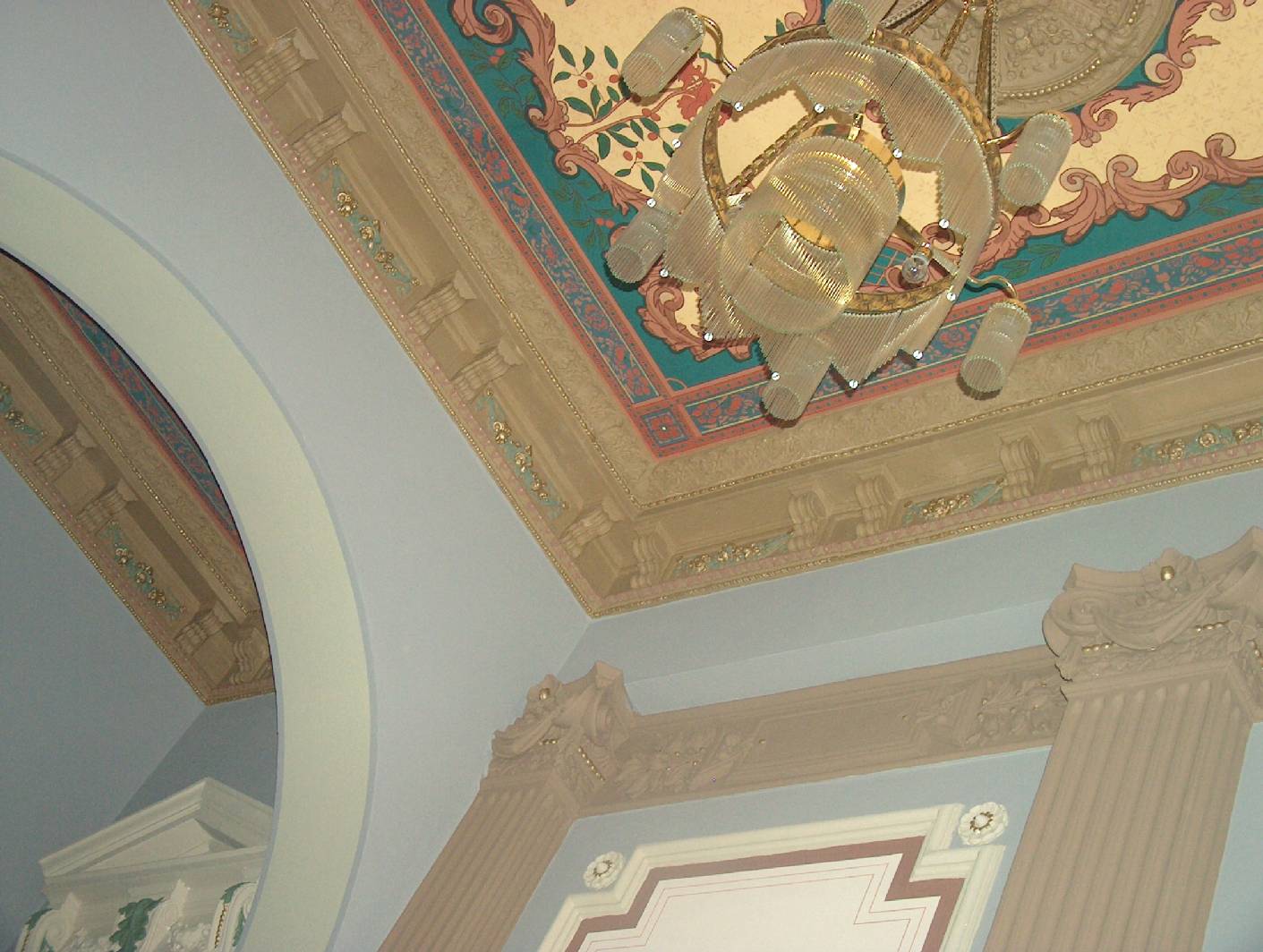 An der Decke in der Durchfahrt des Berliner Altbau – Treppenhaus ‘es befindet sich eine vom Restaurator für historische Malerei arbeitenden Malermeister rekonstruierte Deckenmalerei. Der Stuck wurde überarbeitet, bemalt und vergoldet. Die Vergoldung findet ich auch an den Kapitellen der Säulen wieder. Um die historische Fassung nicht zu beschädigen wurden zuvor die Malerarbeiten auf reversiblen Materialien hergestellt. Das Altbau – Treppenhaus stammt aus dem Berlin der Gründerzeit und hat seinen alten Charme wieder zurückbekommen.