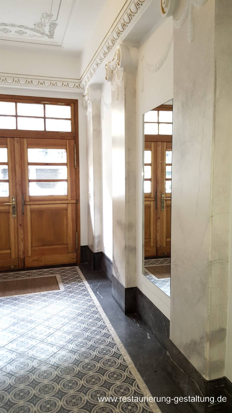 Farblich passend zur Treppenhausgestaltung und sehr dezent hat der Restaurator für Farbgestaltung und Malermeister eine Marmormalerei im Entree  an den Säulen und eine Deckenmalerei als Graumalerei angebracht.