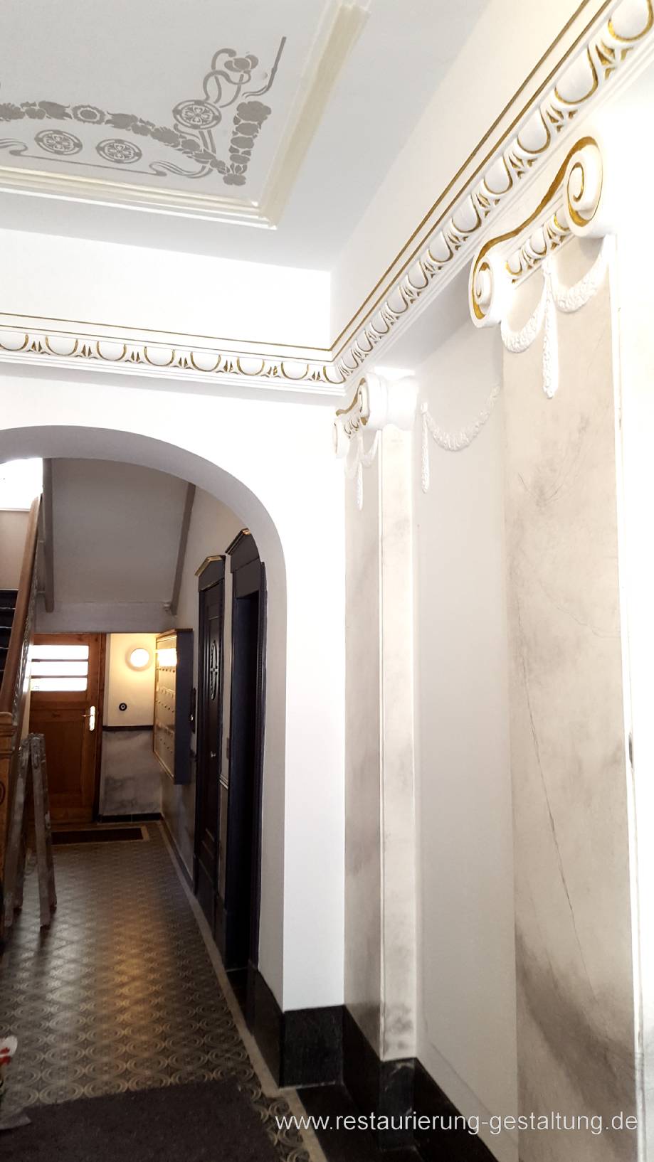 Die helle Marmorimitation an den Säulen bzw. Pilastern ordnet sich dezent in das Entree des Treppenhauses in Berlin Wilmersdorf ein und gibt den Eingang Leichtigkeit. Die Marmorierung der Pilaster / Säulen nimmt die Farbigkeit der Deckenmalerei auf. Die Vergoldung gibt dem Eingang eine edle würde.  Restaurator und Malermeister Schimpf hat 4 angestellte Maler die alle Maler und Vorarbeiten sowie einen großen Teil der kreativen Malerarbeiten Übernehmen. Hierzu gehören die Vorarbeiten und Nacharbeiten der Marmormalerei, Vergoldung im Stuckbereich und die Schablonierung der Deckenmalerei. Die Gestaltung und feine Ausmalung nimmt der Meister selbst vor.