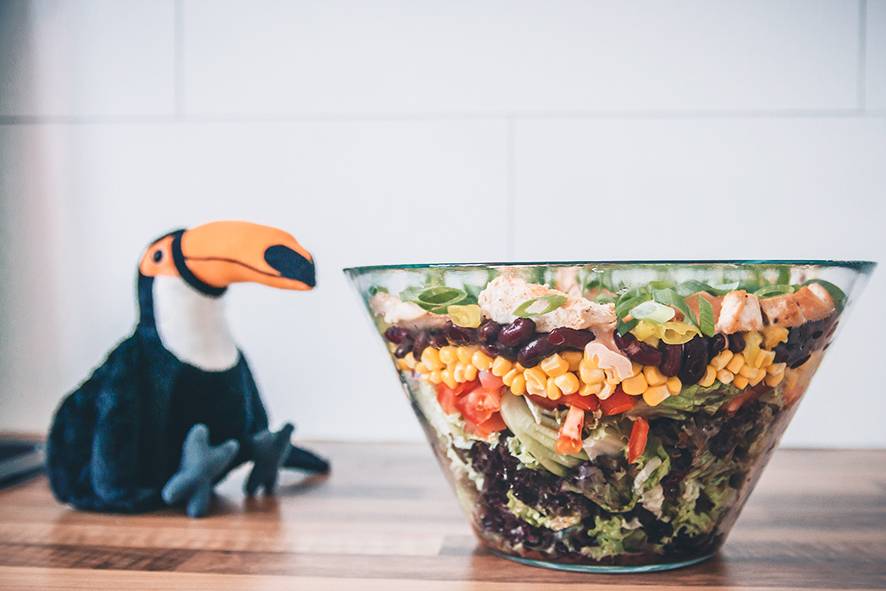 Der Tukan präsentiert eine Schüssel voll Mexikanischem Salat