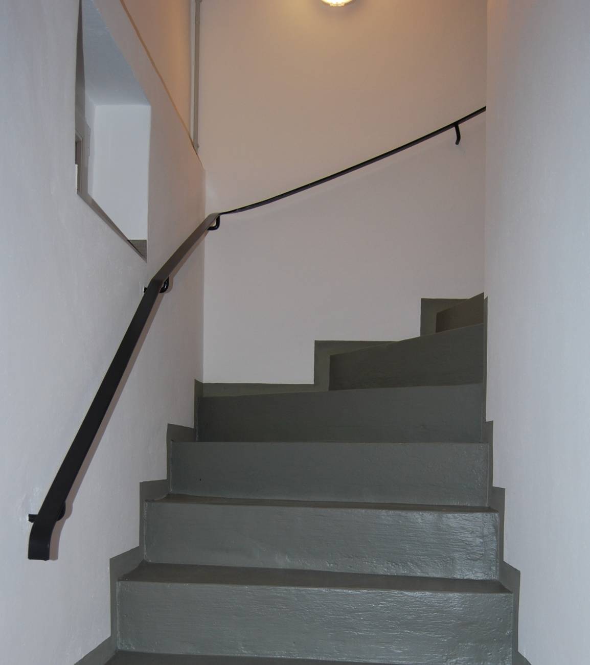 Kellertreppenabgang - durch Lackauftrag erfolgt das Verschließen der Betonporen. Im Fußbereich sollte mit neutralen und rutschhemmenden Farben gearbeitet werden.